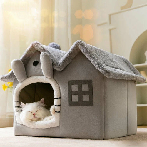 Gray pet house with a cat inside, set against a blurred indoor background